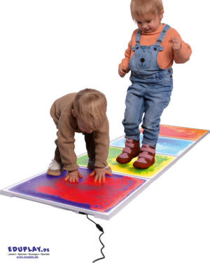 Faszinierende Muster, die im Dunkeln leuchten ... Die LED-Faszinationsplatten animieren Kinder zu experimentieren, wie sich die mit Flüssigkeit gefüllten Platten beim Gehen, Hüpfen, Krabbeln und Drücken mit den Händen verändern. Ganz nebenbei werden Gleichgewichtssinn, Koordination und Körperwahrnehmung gefördert. Die vier Platten können miteinander verbunden werden und benötigen dank des mitgelieferten Netzteils nur einen Stromanschluss. Belastbar bis 80 kg. Material: Kunststoff, Wasser mit farbiger Kosmetikflüssigkeit, Metall Maße: 50 x 50 x 1,2 cm